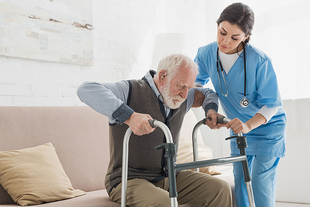 Trained patient attendant assisting an elderly patient at home in South Delhi - Mother Health Care Services